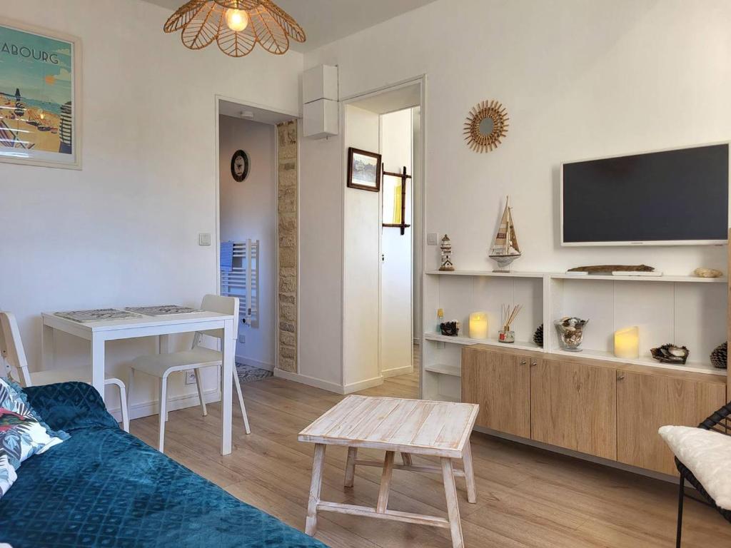 un salon avec un canapé et une table dans l'établissement Studio cosy avec parking, à 100m du centre, proche plage - FR-1-788-47, à Merville-Franceville-Plage