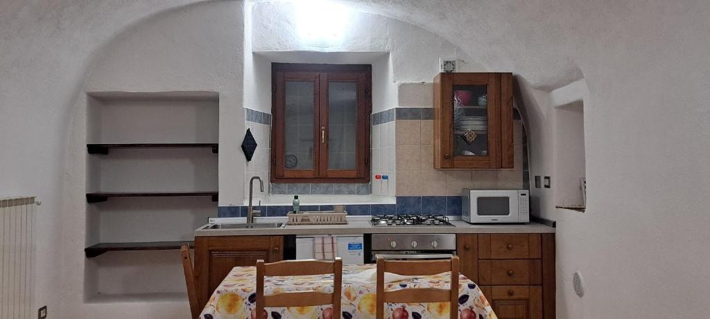 a kitchen with a table with two chairs and a microwave at Casa Grande appartamento Marianna in Pragelato