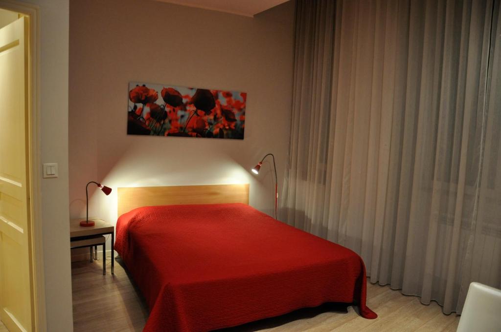 une chambre avec un lit avec une couverture rouge dans l'établissement Les Studios De La Place (Part-Dieu), à Lyon