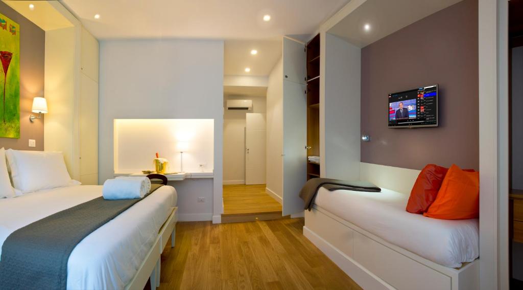 Habitación de hotel con 2 camas y TV en la pared en Ripense In Trastevere, en Roma