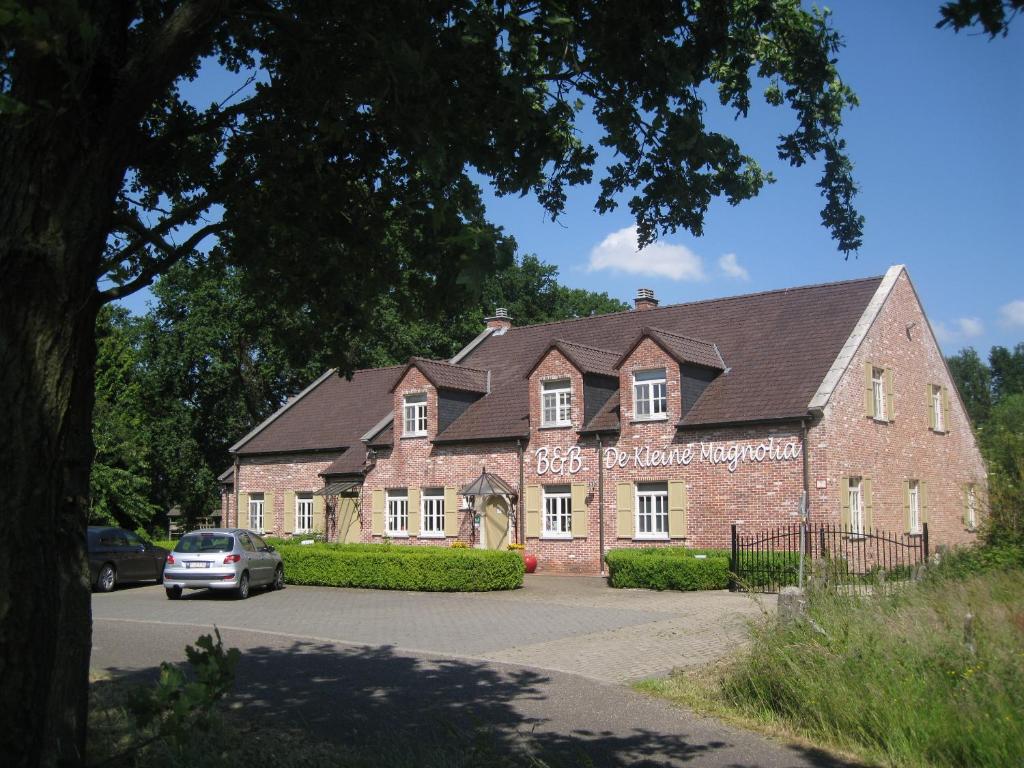 a large brick building with a sign on it at Bed &amp; Breakfast De Kleine Magnolia in Tessenderlo