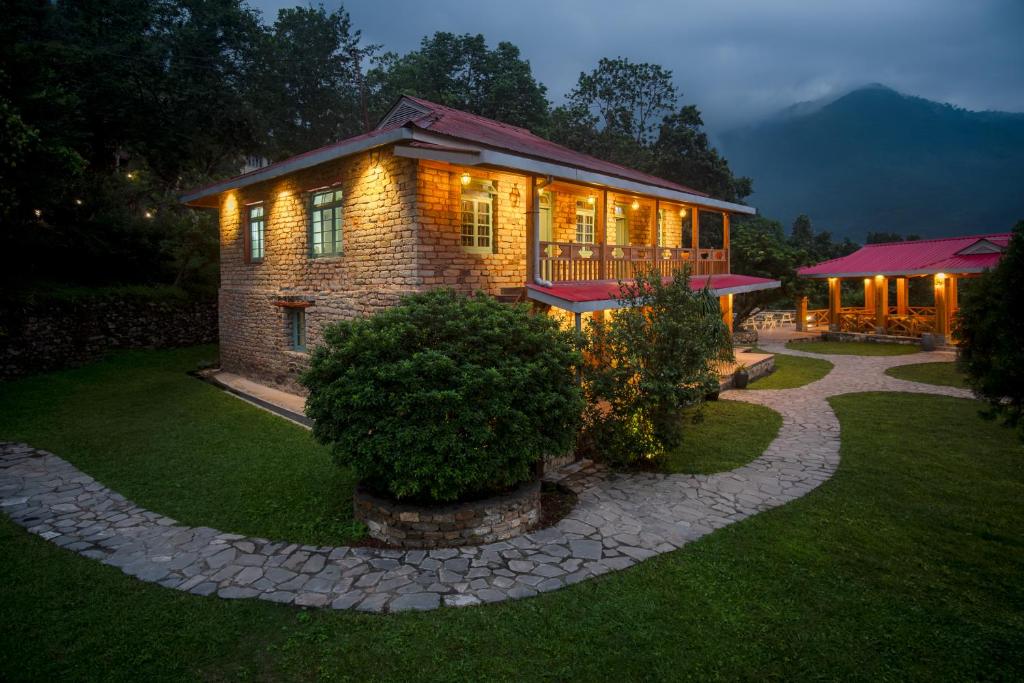 a brick house with lights on in a yard at night at Martam Village Resort in Gangtok