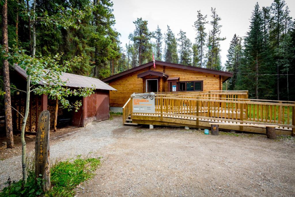 a cabin in the woods with a large wooden deck at HI Athabasca Falls - Hostel in Jasper