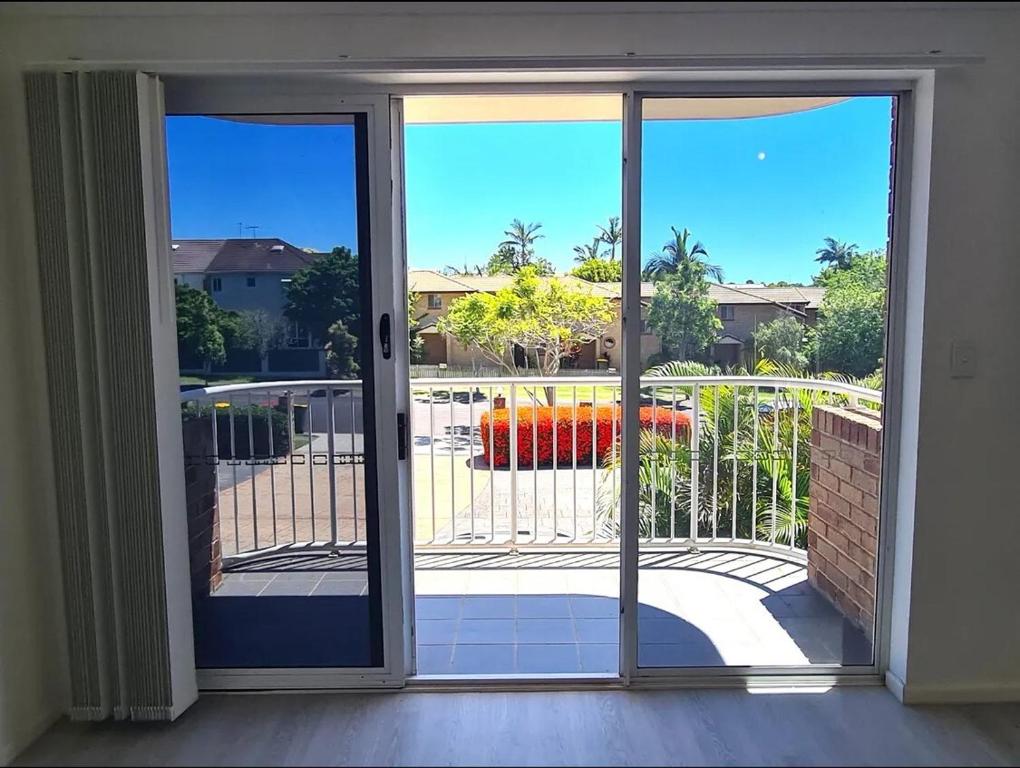 una porta scorrevole in vetro con vista su un patio di A 3 bedders close to everything a Brisbane