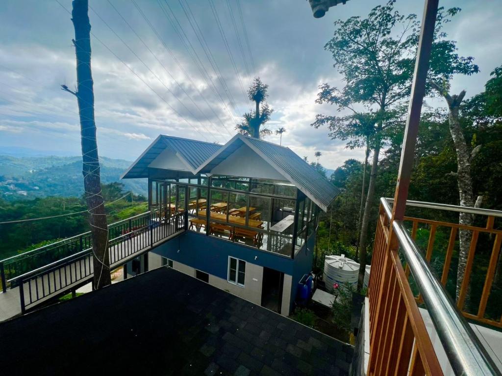 a house with a blue roof and a balcony at Misty Bush Munnar in Munnar
