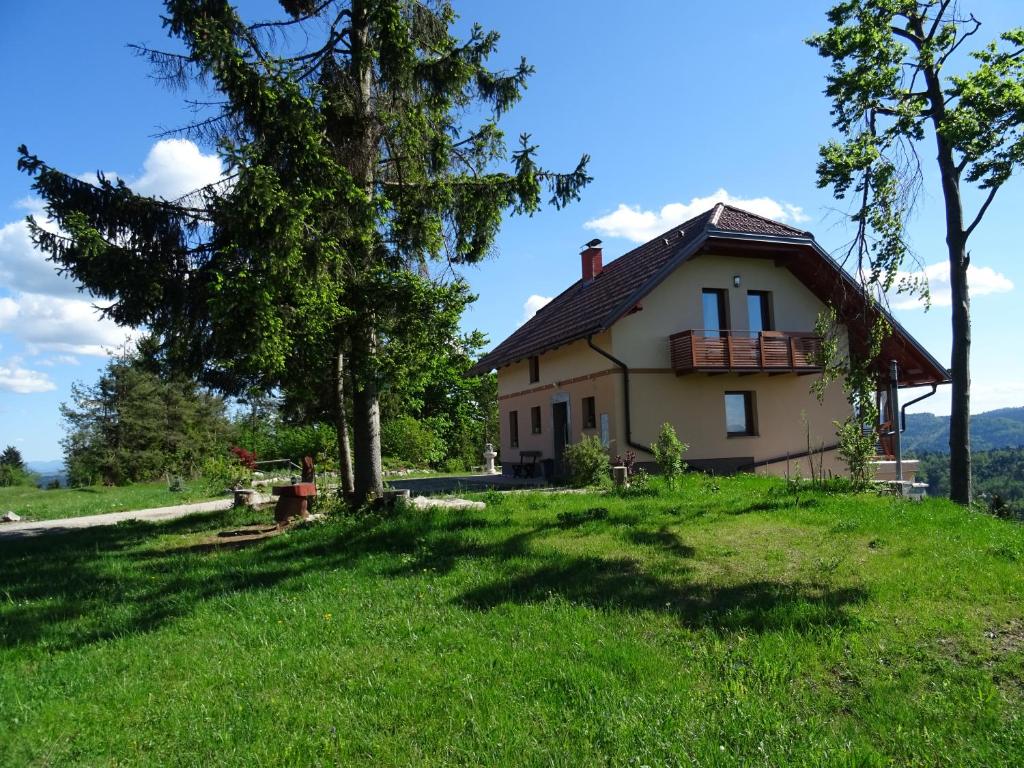 uma casa numa colina com uma árvore em Holiday Home Razglednik em Logatec