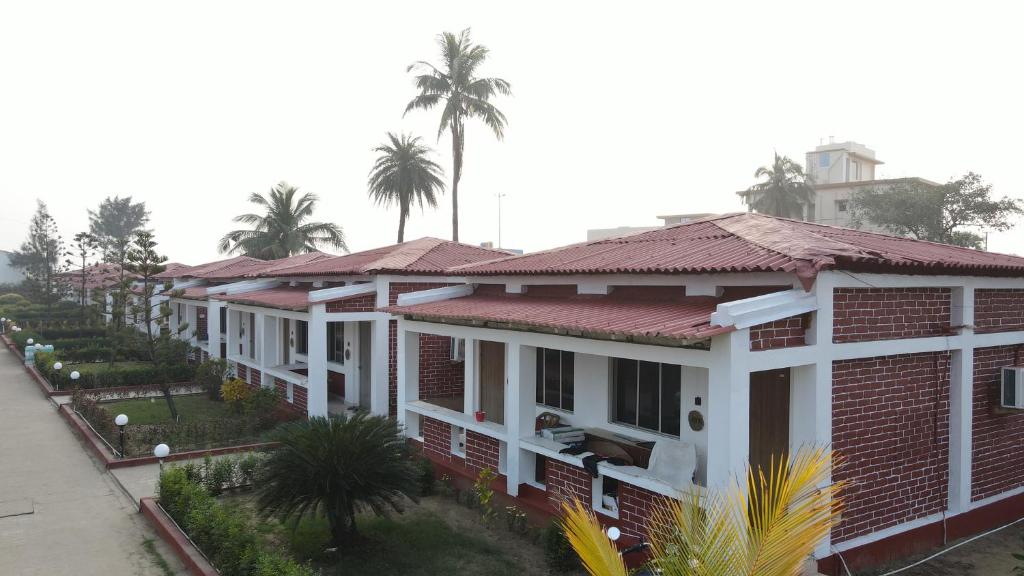 a row of houses with palm trees in the background at Ricardo Beach Resort in Mandarmoni