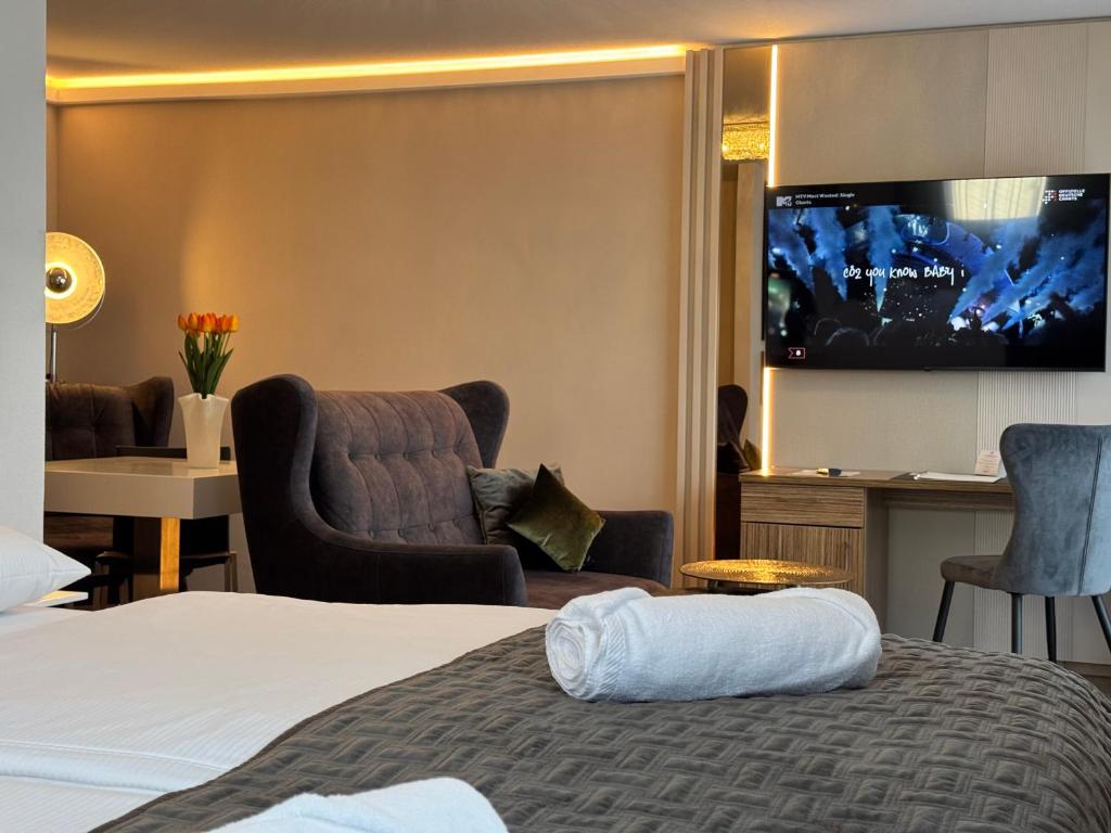 a hotel room with a bed and a flat screen tv at Boardinghouse HOME - adults only - in Konstanz