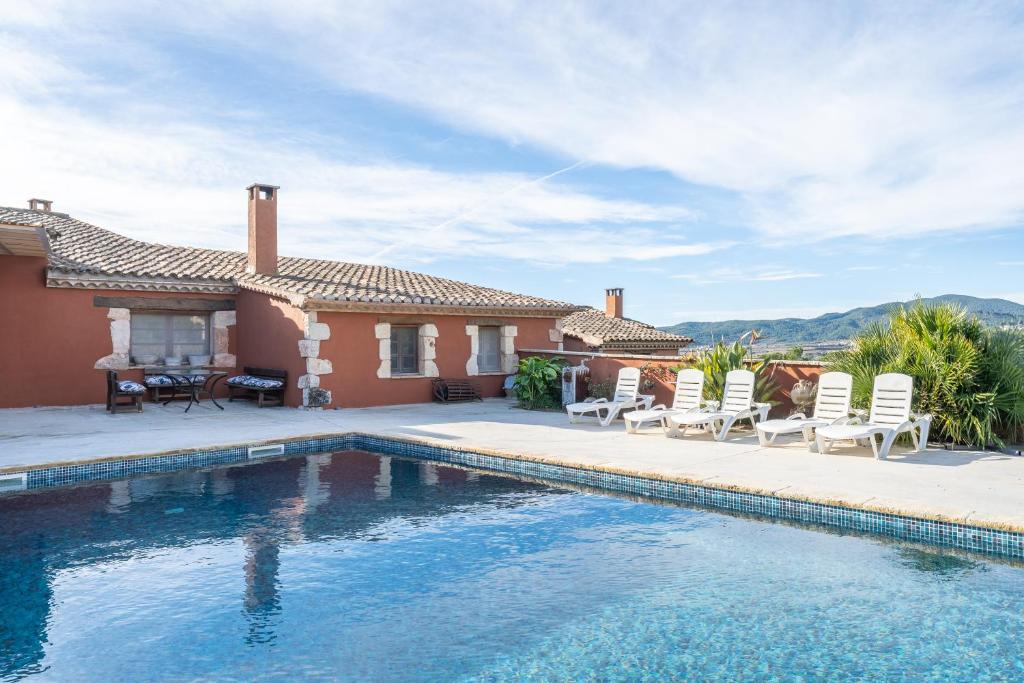 a villa with a swimming pool in front of a house at Ca la Munda-Can Cruset Agroturisme in Torrellas de Foix