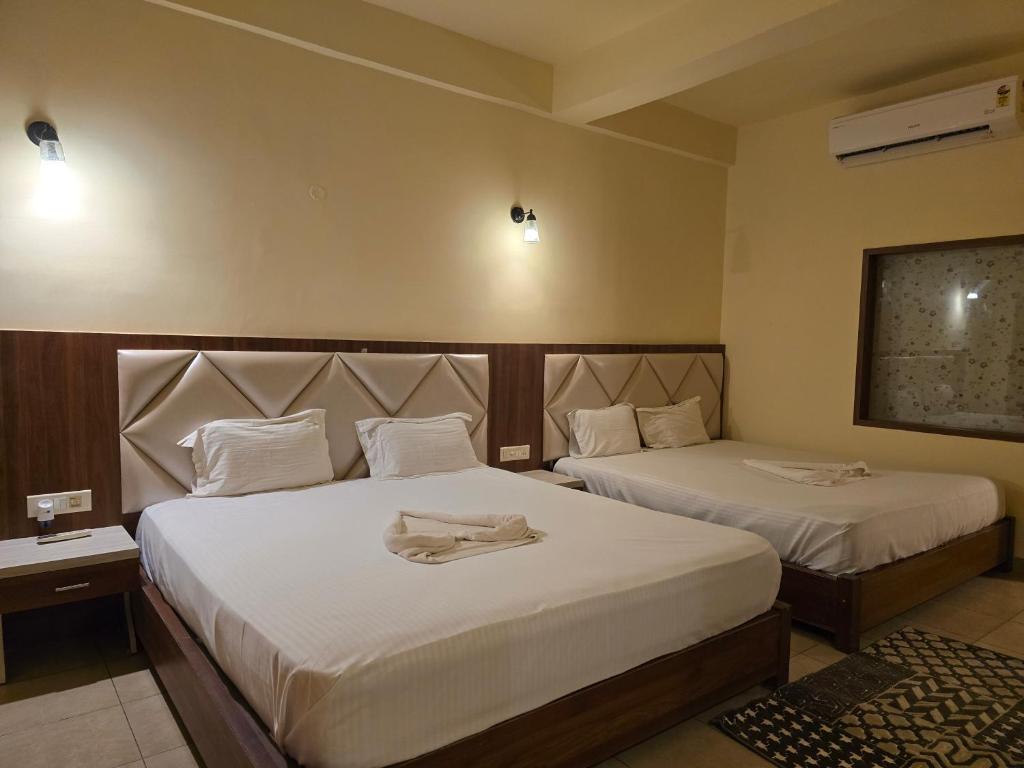 a hotel room with two beds with towels on them at Ricardo Beach Resort in Mandarmoni