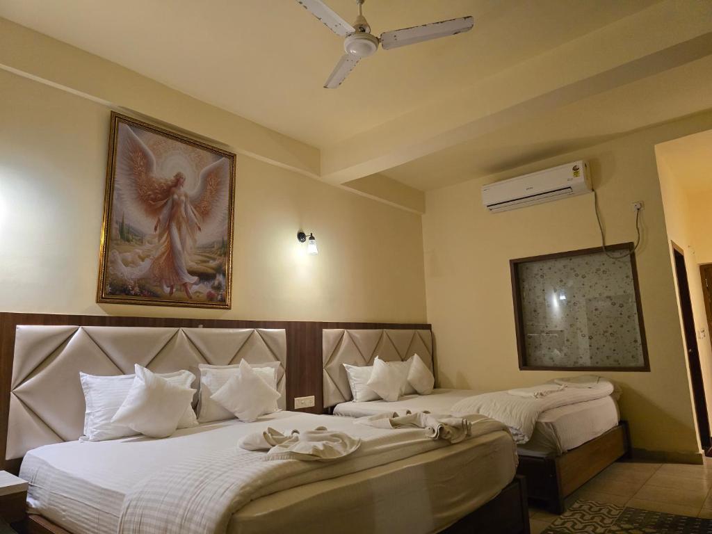 a hotel room with two beds and a painting on the wall at Ricardo Beach Resort in Mandarmoni