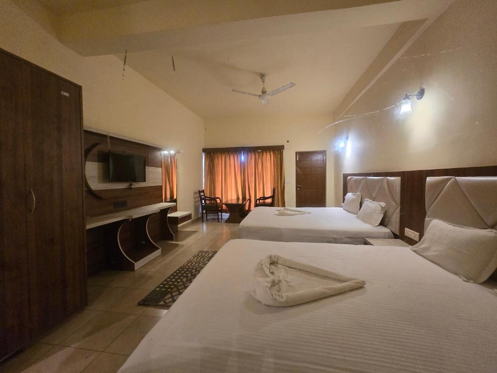 a hotel room with two beds and a television at Ricardo Beach Resort in Mandarmoni