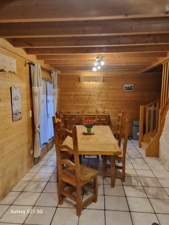 une salle à manger avec une table et des chaises en bois dans l'établissement Chalet bois et pierre, à La Bresse