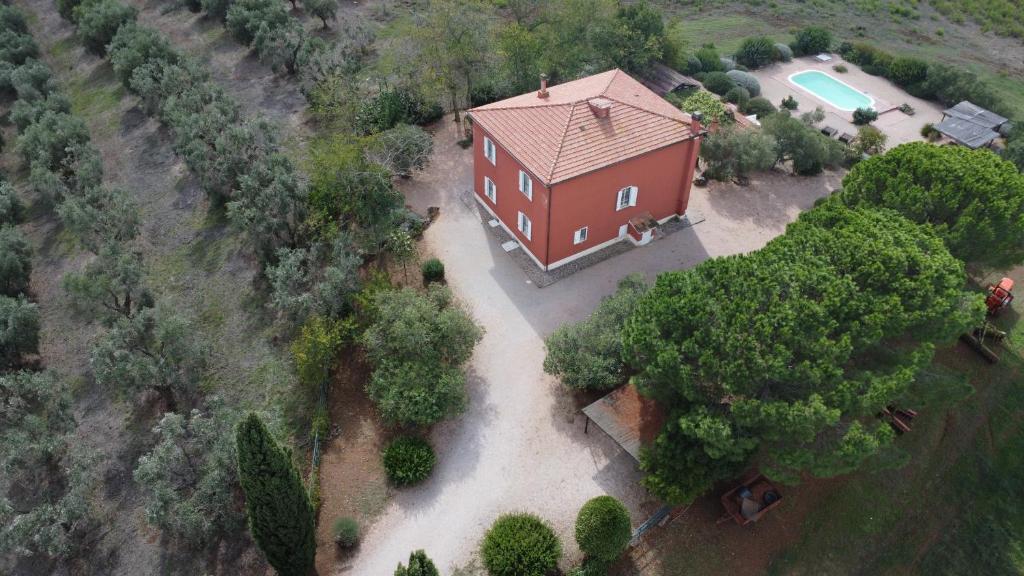 - une vue sur une grande maison rouge avec une piscine dans l'établissement La Villa de I Casali del Troscio, à Capalbio