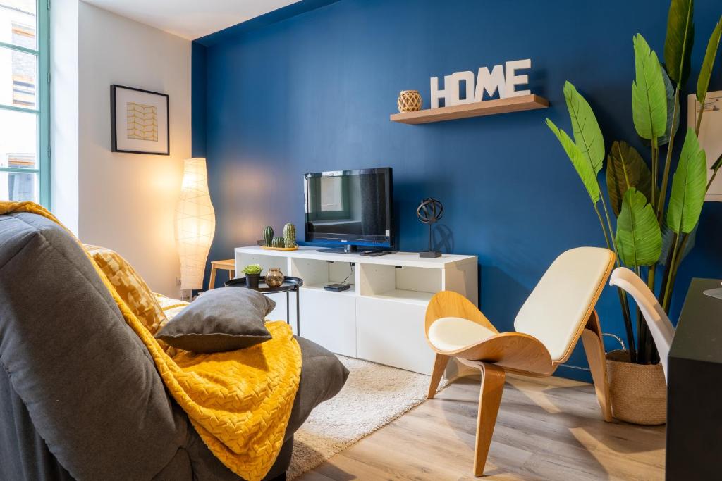 - un salon avec des murs bleus, un canapé et des chaises dans l'établissement Appartement central-Wifi-Netflix, à Montélimar