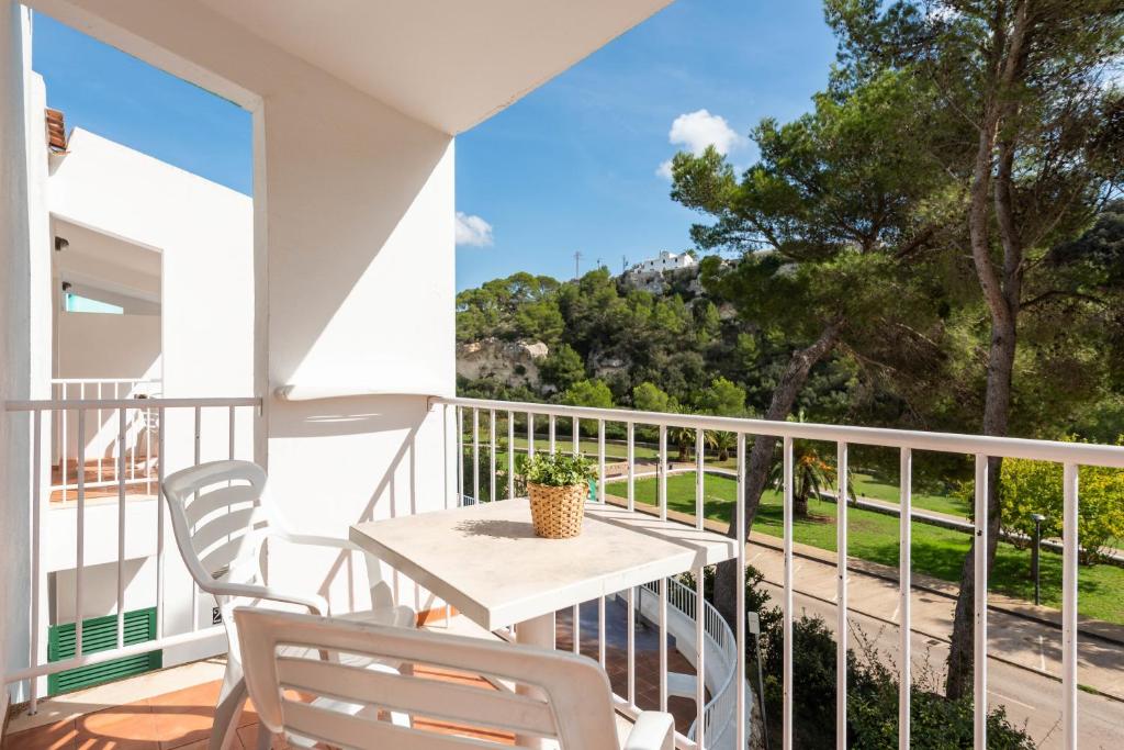 a balcony with a table and chairs and a view at Apartamentos alta galdana playa in Cala Galdana
