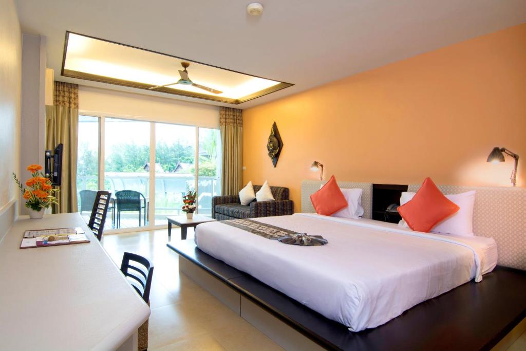 a bedroom with a large bed and a living room at Anyavee Tubkaek Beach Resort in Tab Kaek Beach