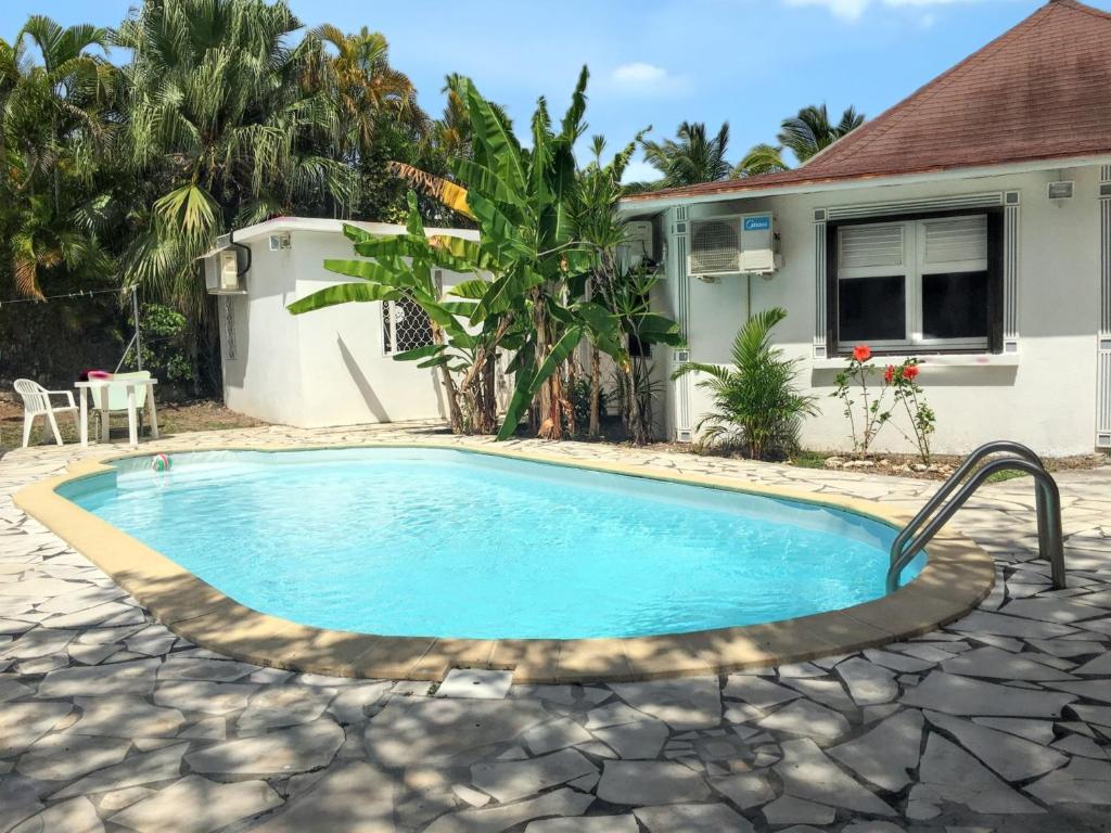 uma piscina em frente a uma casa em Maison accueillante à Saint-François avec piscine privée. em Saint-François