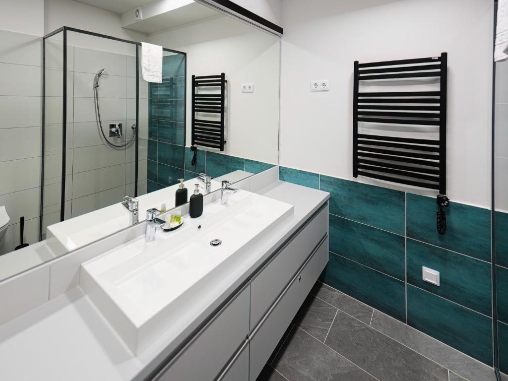 a bathroom with a white sink and a mirror at Soling apartmanház Velence in Velence