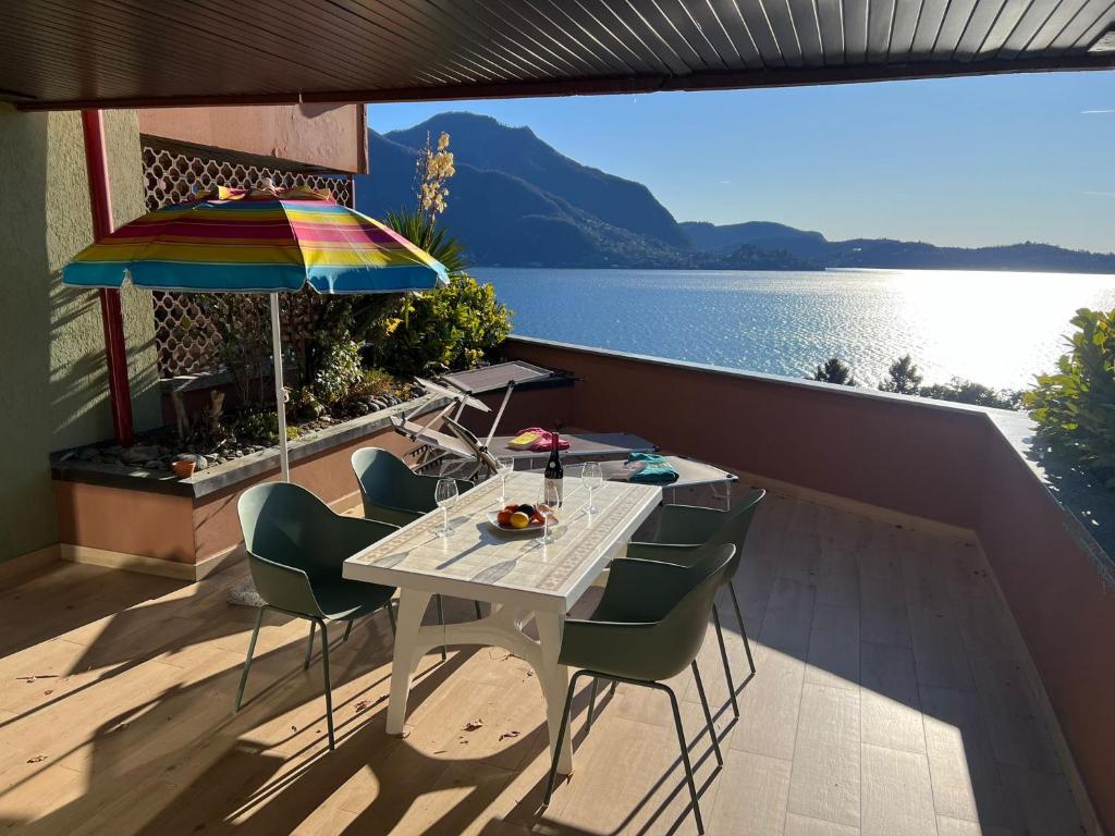 a table and chairs on a balcony with a view of the water at Bella Rosa in Ghiffa