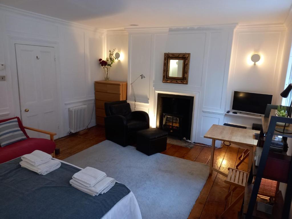 a living room with a bed and a fireplace at Large Bright Soho Studio flat with Large Terrace in London