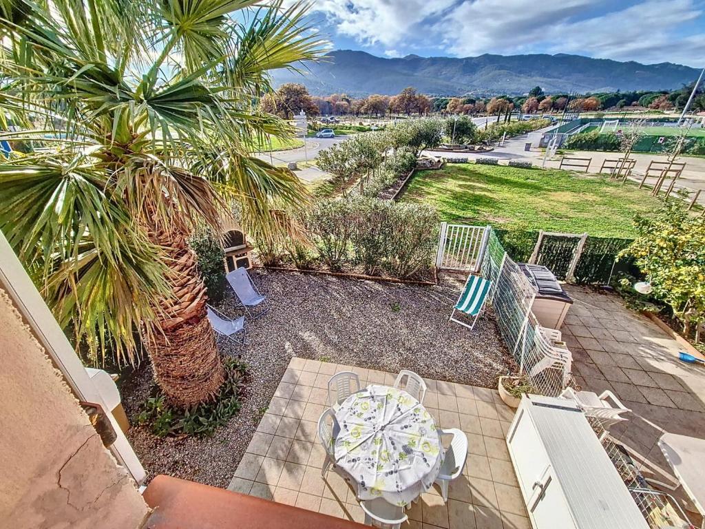 un patio avec une table, des chaises et un palmier dans l'établissement VILLA PROCHE MER ET MONTAGNE - Vacances sans voiture, à Argelès-sur-Mer