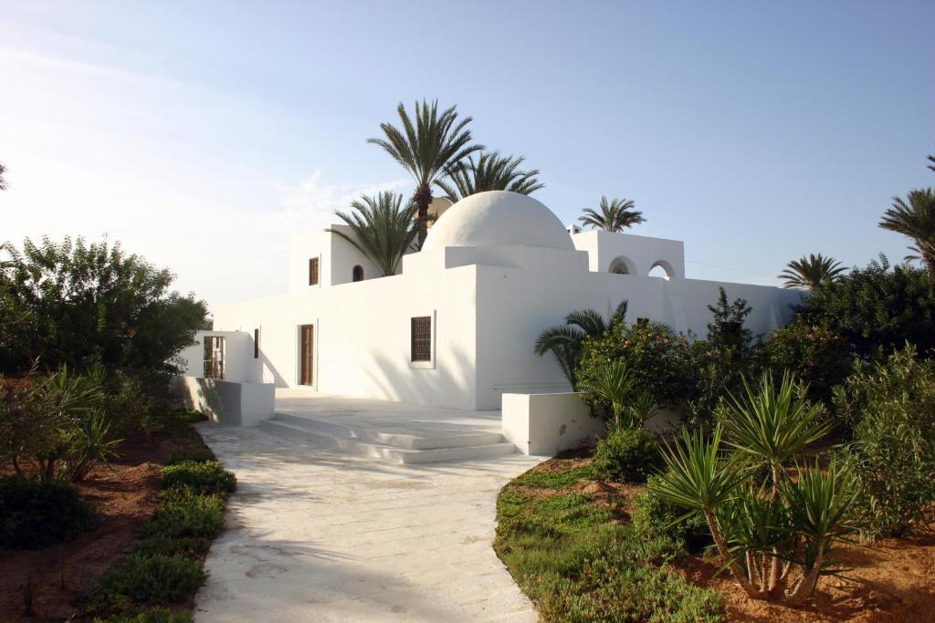 une maison blanche avec des palmiers en arrière-plan dans l'établissement Menezel Jerba, à Djerba