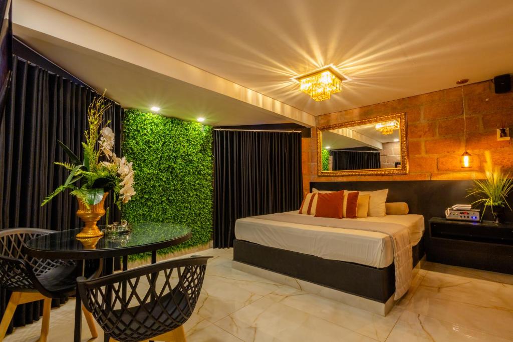 a bedroom with a bed and a table and a green wall at Motel Paradiso - Ibirubá-RS in Ibirubá