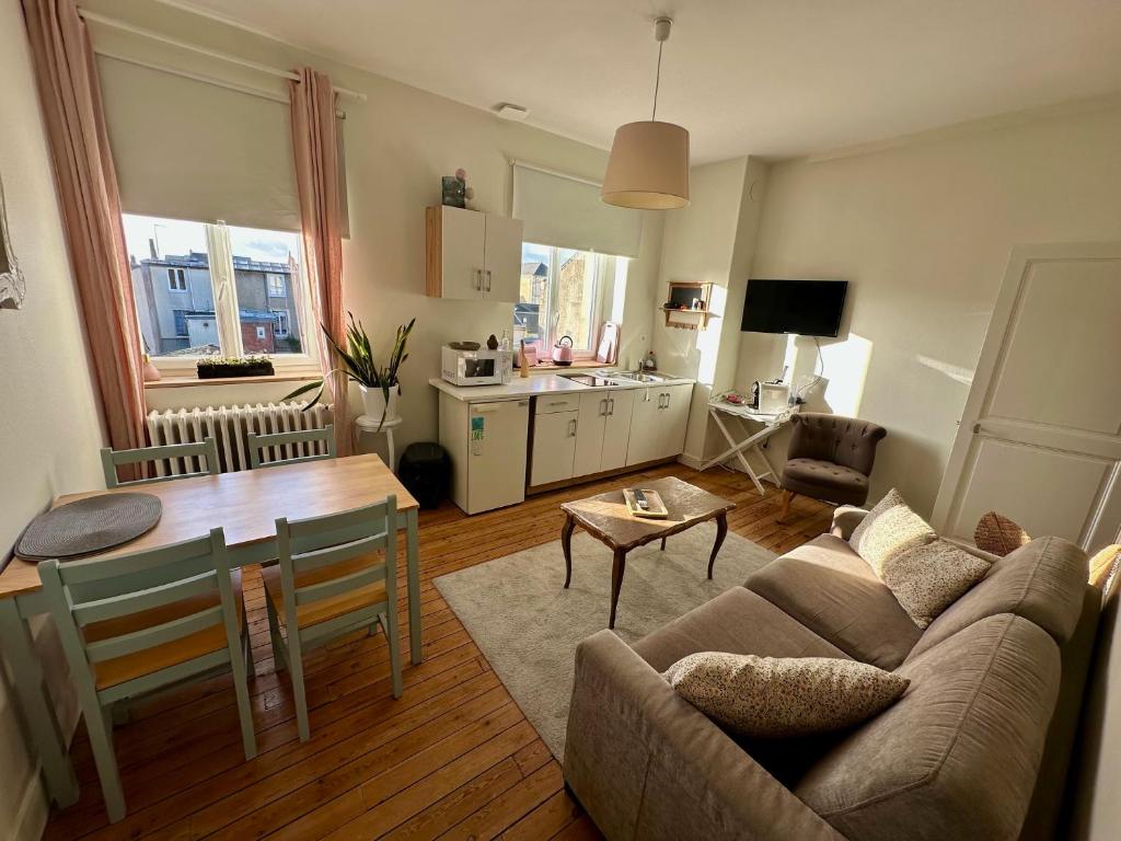 un salon avec un canapé et une table dans l'établissement La Douceur - 4 personnes - BCLA, au Mans