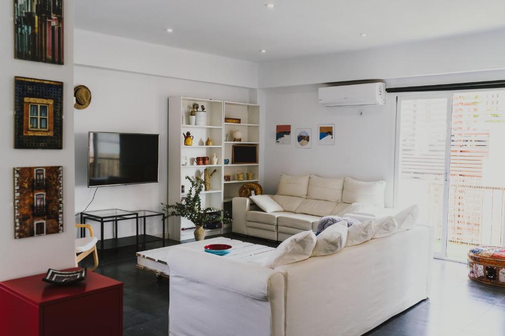 un soggiorno con un divano bianco e una TV di Cathedral - City Center - Free Parking - Climatized a Almería