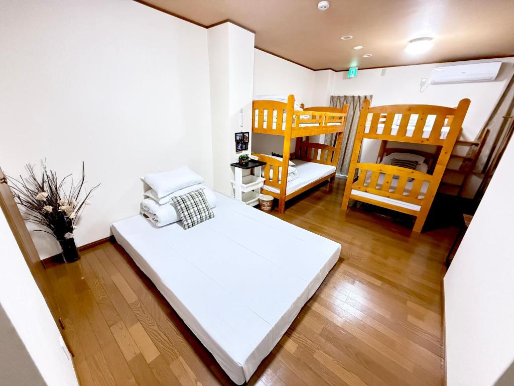 Postel nebo postele na pokoji v ubytování PetitHotel017全室ミニキッチン付きファミリルーム 飲食街中心 阿波踊り会館7分 文理 徳島大学 アスティとくしま車8分