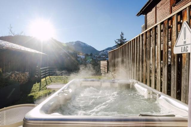 a hot tub with water in it next to a building at Ride and Breakfast in Montriond