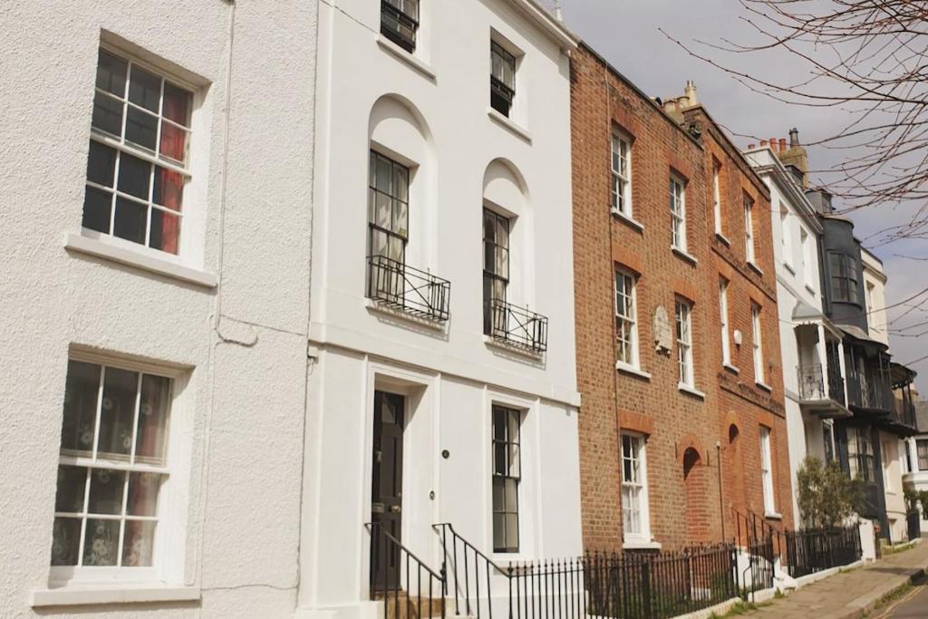 a white building on a street with brick buildings at Stanhope House in Hastings