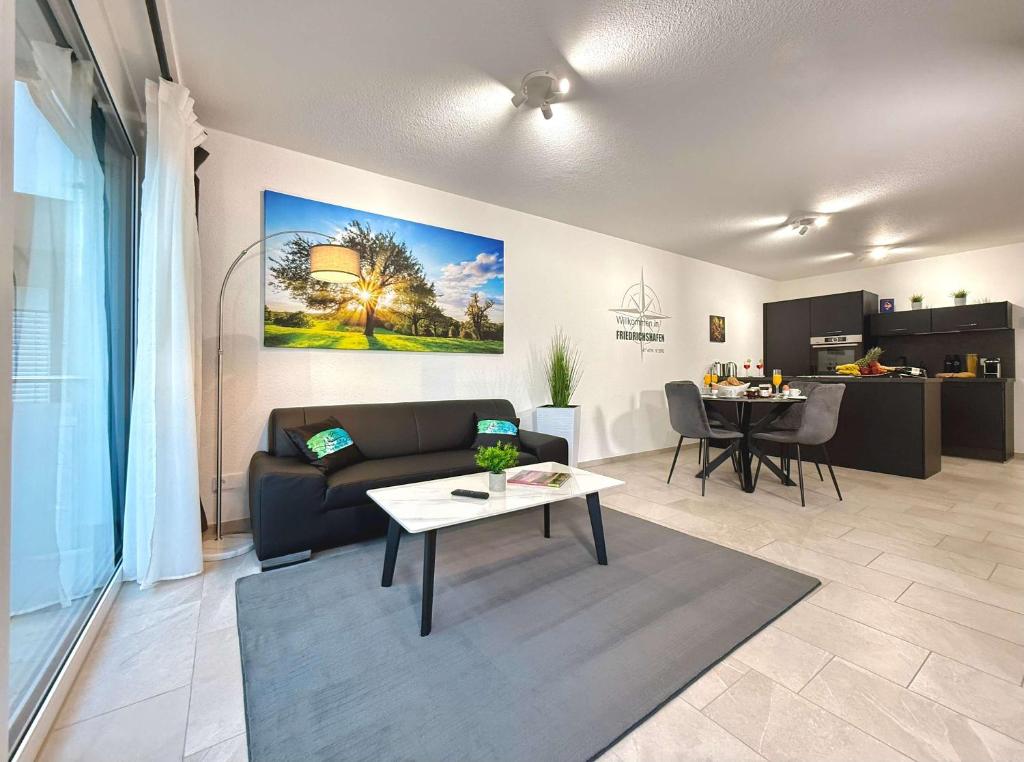 a living room with a couch and a table at Auszeit Apartment EMOTION in Friedrichshafen