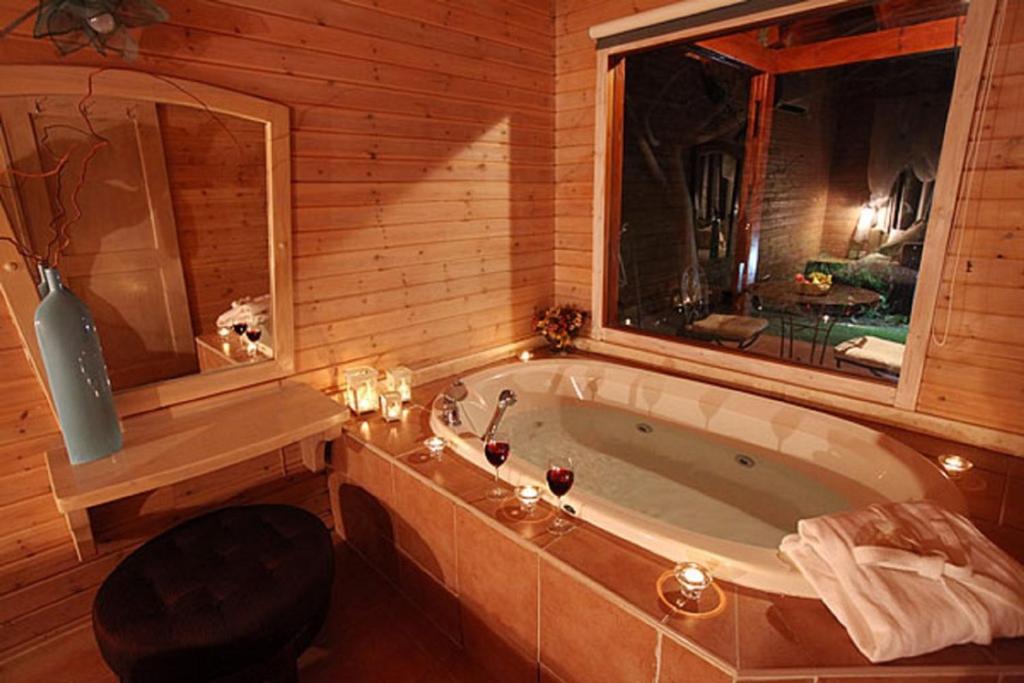 a bathroom with a large tub in a wooden room at מול הנוף ברמות in Moshav Ramot