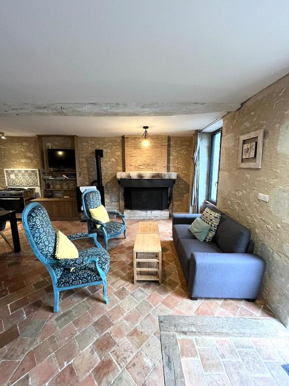 un salon avec un canapé, des chaises et une table dans l'établissement Les gîtes de Lou, entre Blois et Chambord, à La Chapelle-Saint-Martin-en-Plaine