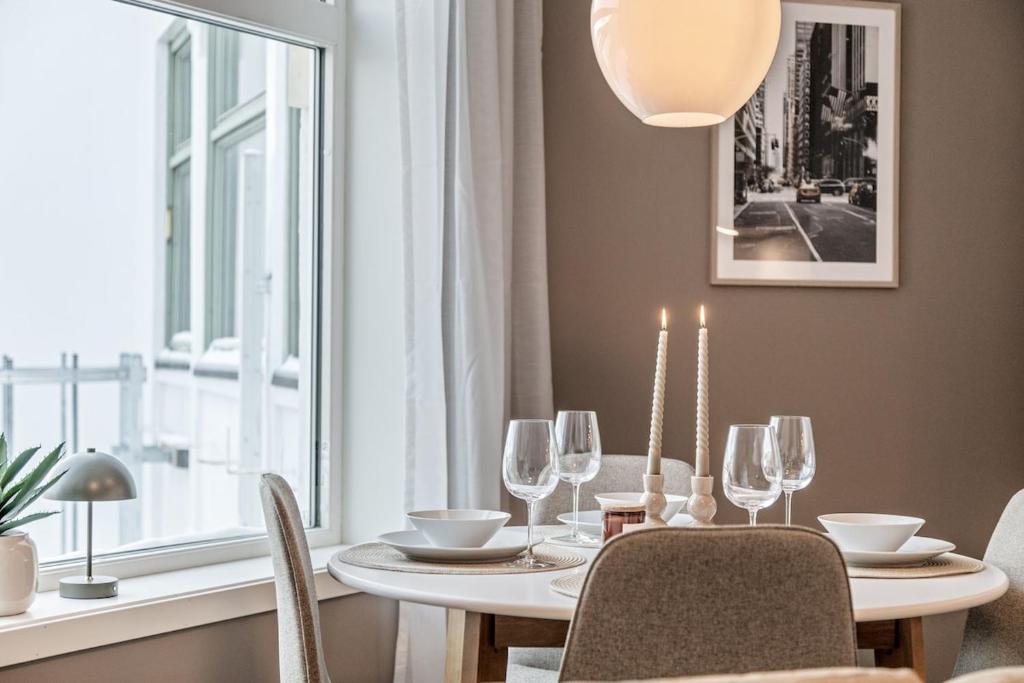a dining room with a table and chairs and a window at 4 bedroom Penthouse Appartment, Right On The Mainstreet in Kongsberg