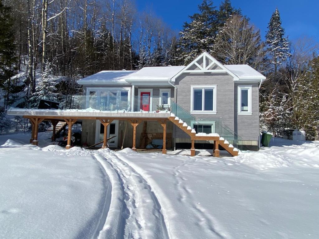 a house in the snow with a snow covered driveway at Nature, hot tub and relaxation at its best! in Val des Monts