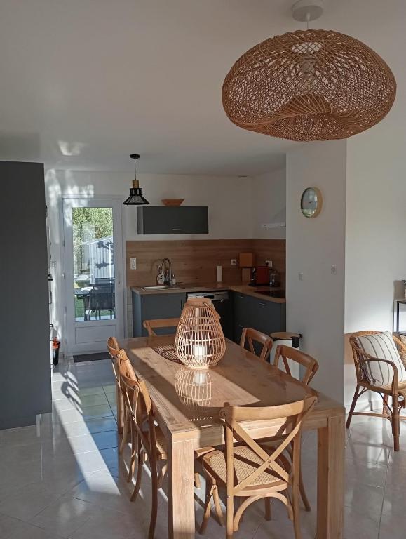une salle à manger avec une table et des chaises en bois dans l'établissement Maison proche de la plage, à La Brée-les-Bains