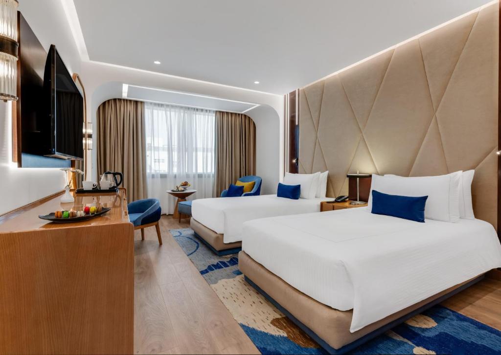 a hotel room with two beds and a desk at Sonesta Hotel Tower & Casino Cairo in Cairo