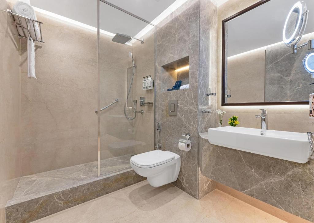 a bathroom with a shower and a toilet and a sink at Sonesta Hotel Tower & Casino Cairo in Cairo