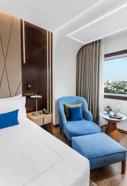 a bedroom with a bed and a chair and a window at Sonesta Hotel Tower & Casino Cairo in Cairo