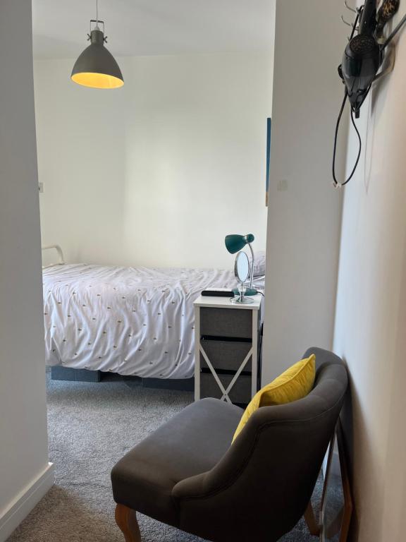 a bedroom with a bed with a chair and a table at Cliftonville House in Whitstable