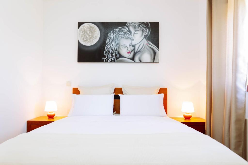 Un dormitorio con una cama blanca con dos lámparas. en Casa Fundevila Celorico de Basto by AloTur, en Celorico de Basto