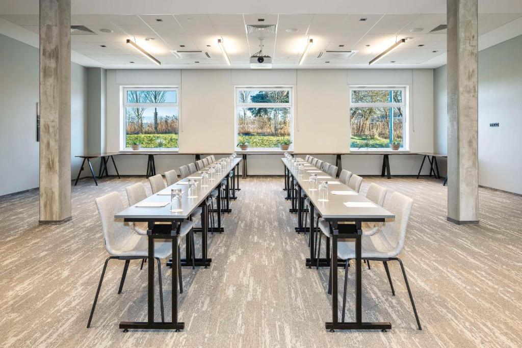 a classroom with tables and chairs in a room with windows at Park Inn by Radisson Vilnius Airport Hotel & Conference Centre in Vilnius