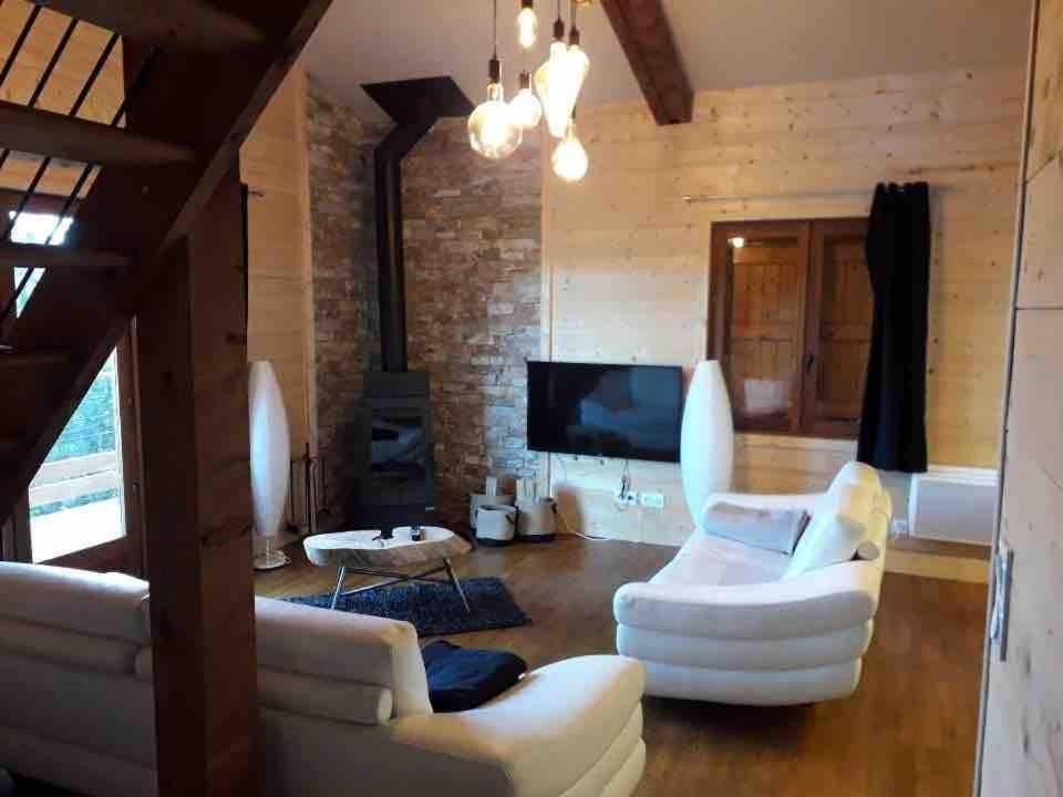 - un salon avec deux canapés blancs et une télévision dans l'établissement Chalet sur les hauteurs des Angles, aux Angles