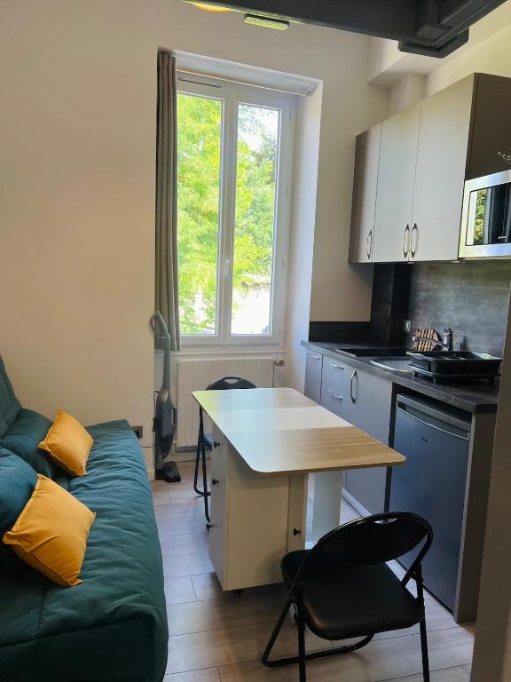 - une cuisine avec un canapé et une table dans une chambre dans l'établissement Studio Georges 1er, à Aix-les-Bains