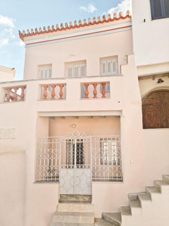 a white house with a gate and stairs at Abella Maison, Kythnos in Kithnos