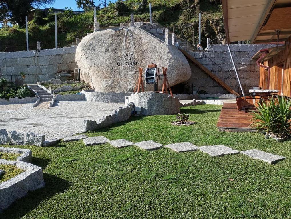 a statue of a person standing next to a large rock at Casa do Outeiro in Arcos de Valdevez