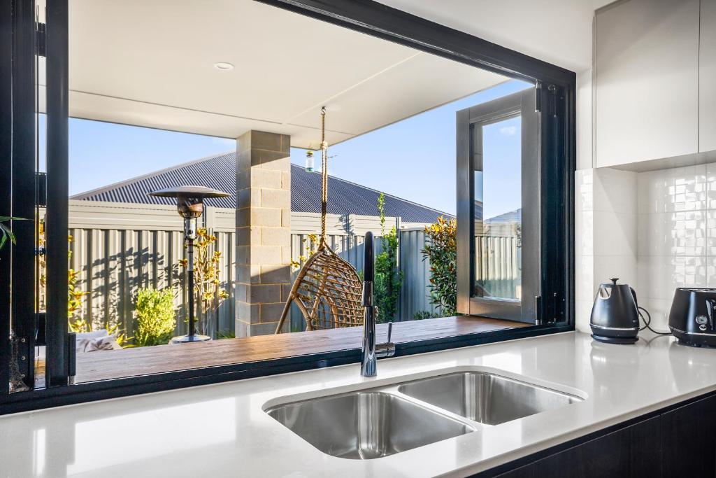 AlkimosにあるAmberton Beachs Little Paradise By Swan Bnbのシンクと大きな窓のあるキッチン